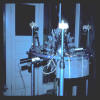 Early mounting of the optical resonator (1986); central crystal is a quartz sphere with a facet for each mirror. Note He-Ne laser which with a photodiode detected crystal vibrations.